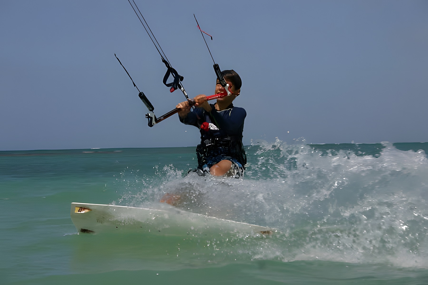 Teenage Hugo Beaumont carving a toeside spray on his kiteboard